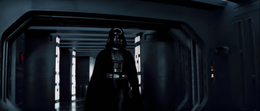 Vader walking into another corridor meeting with some TIE fighter pilots.