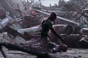 Deadpool standing victorious over Ajax and pointing a gun to his head.