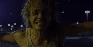A flayed Billy using his strength to open a gate as he chases Mike, El, and Max.