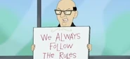 Pankley holding a sign saying "We Always Follow the Rules"