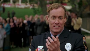 Sisk applauding in anger and jealousy at Mange after saving the mayor's son from drowning