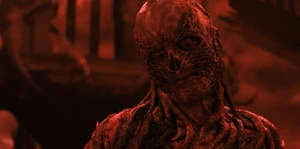 Vecna smiling evilly as he restrains and chokes Max with the vines.