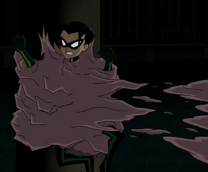 Clayface II trapping Robin against a pillar.