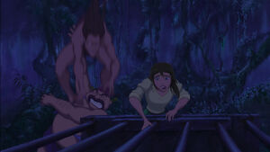 Tarzan jumping onto the thug's shoulders, knocking him out.