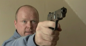 Phil takes possession of Dan's handgun after disarming the latter from it during their fight (2001).