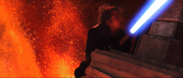 Vader holding on to a portion of the structure with his lightsaber ignited.