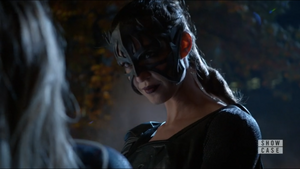 Reign smirking sadistically as she overpowers Supergirl.