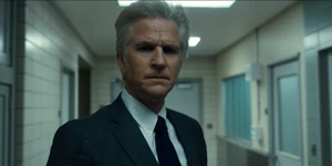 Brenner standing in a hallway.