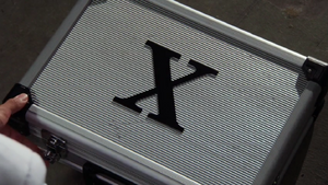 A suitcase with the Foundation X logo on it.