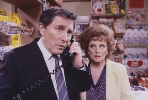 Alan has a business phone call in front of Rita.