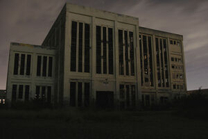 The building where the events took place. This is the building in the standard SCP timeline, not the one it teleported from.