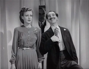 Grover behind Joan and Flywheel as they are about to have their picture taken by Ravelli