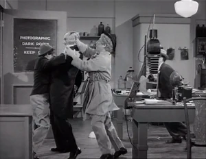 Grover restrained by Ravelli while Wacky takes back the picture