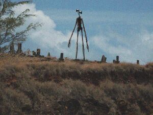 The original image of Siren Head, standing on top of a hill in a graveyard.