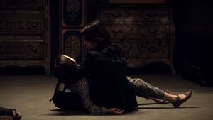 May holding Katya's body after being forced to kill her.