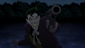 Joker draws his gun on Batman.