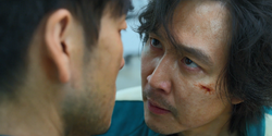 Gi-hun arguing with Sang-woo.