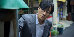 Sang-woo watches his mother organizing her fish store, but has no courage to face her.
