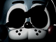 A broken Toy Bonnie mask, representing Bonnie Glade.