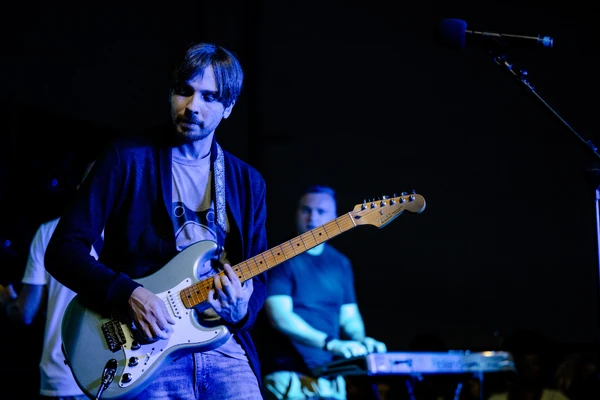 Vinny in the middle of playing the guitar.