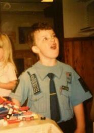 A young Joel dressed in his favorite shirt, a play police uniform