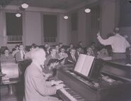 Tuttle conducting Glee Club rehearsal with Thompson accompanying