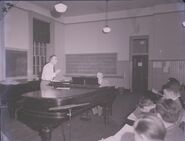 Tuttle conducting Glee Club rehearsal with Thompson accompanying