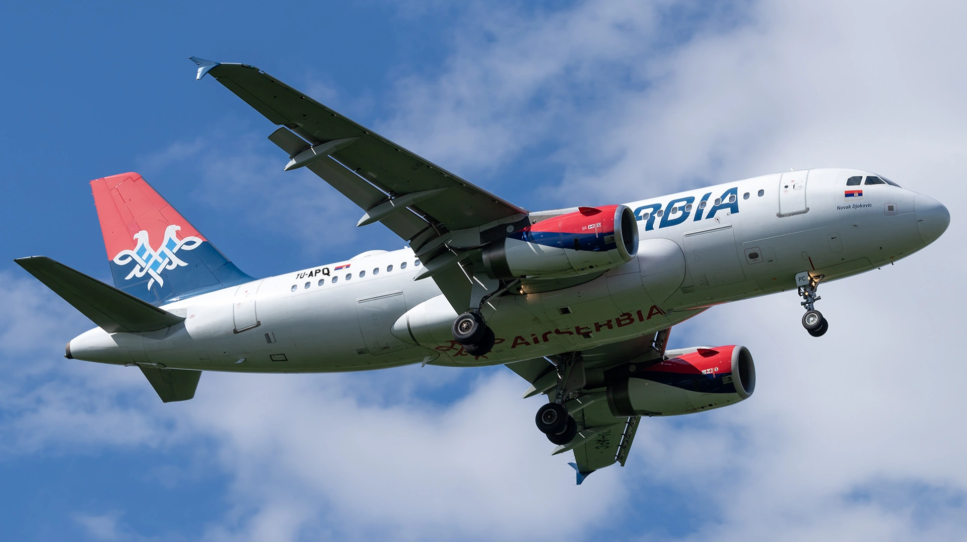 Air Serbia Flight 827 flying on blue sky with some white clouds