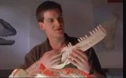 Scott Sampson holding Tyrannosaurus rex jaw and below with Majungasaurus skull.