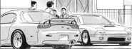 Susumu with friend alongside parked RX-7s.