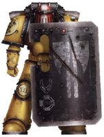 A Pre-Heresy Imperial Fists Legion Breacher Siege Squad Veteran Sergeant; note that this Legionary's shield bears the chevrons of a Sergeant, further marked as a Veteran by the central lozenge while the twined axes symbolise having served alongside the famed Seneschal Fafnir Rann and the red helmet identifies him as a Sergeant and the white stripe as a Veteran of the Legion