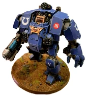 A Redemptor Dreadnought of the Ultramarines Chapter armed with a Macro Plasma Incinerator, Redemptor Fist, Icarus Rocket Pod (above head), 2 Fragstorm Grenade Launchers (in torso) and Heavy Flamer (below Redemptor Fist)