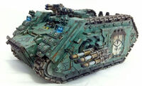 A Spartan Assault Tank of the Sons of Horus Legion equipped with extra armour plating, Frag Assault Launchers, a Pintle-mounted Multi-Melta, and a Hunter-Killer Missile Launcher