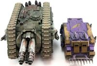 A Cerberus Heavy Tank Destroyer of the Iron Hands Legion and a Deimos Rhino of the Emperor's Children Legion, side-by-side size comparison