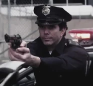 A police officer aiming a loaded gun at Jimmy and O'Brien