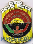 Эмблема инженерных частей. Выполнена в национальных цветах, надпись переводится как "военные инженеры", а изображение строительной машины обозначает собственно самих инженеров.