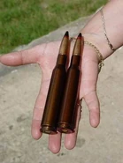 12,7-мм патроны на человеческой ладони.