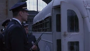 Охранники, вооруженные Winchester 12, встречают автобус с новыми заключенными.