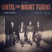 Black and white photograph of the members of Lord Huron walking down an alley.