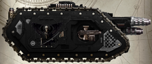 An Obsidian Spears relic Cerberus Heavy Tank Destroyer assigned to the 3rd (Battle) Company ("The Lancers"). Note: This vehicle bears the emblem of the Host of Walls, which is appropriate, as this particular Host are experts in breaking the momentum of an attacking enemy force as well as defeating even the most overpowering of foes. Also of note, is the 'Dark Angel of Judgement', a common allegorical image utilised by the Obsidian Spears. Few can doubt the meaning of this grim spectre of death adorning the side of this vehicle.