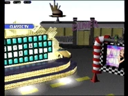 Another view of the "Fast Cars" stage as the Wheel spins and Vanna is seen clapping on the video monitor