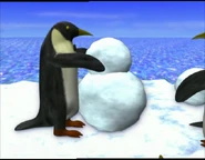 Penguins making a snowman