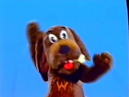 Puppet Wags holding a bone in his mouth