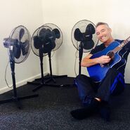 Anthony playing his blue Maton acoustic guitar in 2014