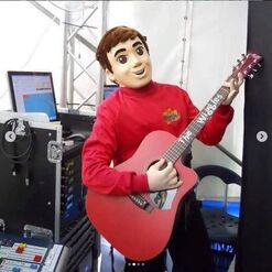 Mascot Murray playing red Maton Acoustic guitar