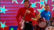 Murray playing his red Maton electric guitar in "Santa's Rockin'!"