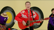 Simon playing his red Maton acoustic guitar