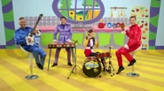 The Wiggles playing their instruments in the Wiggle House kitchen