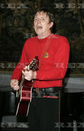 Murray playing his red Maton acoustic guitar at the High Commission