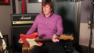 Murray showing Red Fender Stratocaster guitar